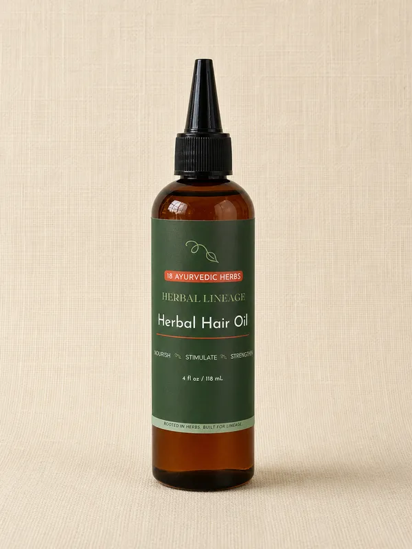 Herbal Hair Oil amber applicator bottle with green label and terracotta 18 Ayurvedic Herbs badge, on cream linen